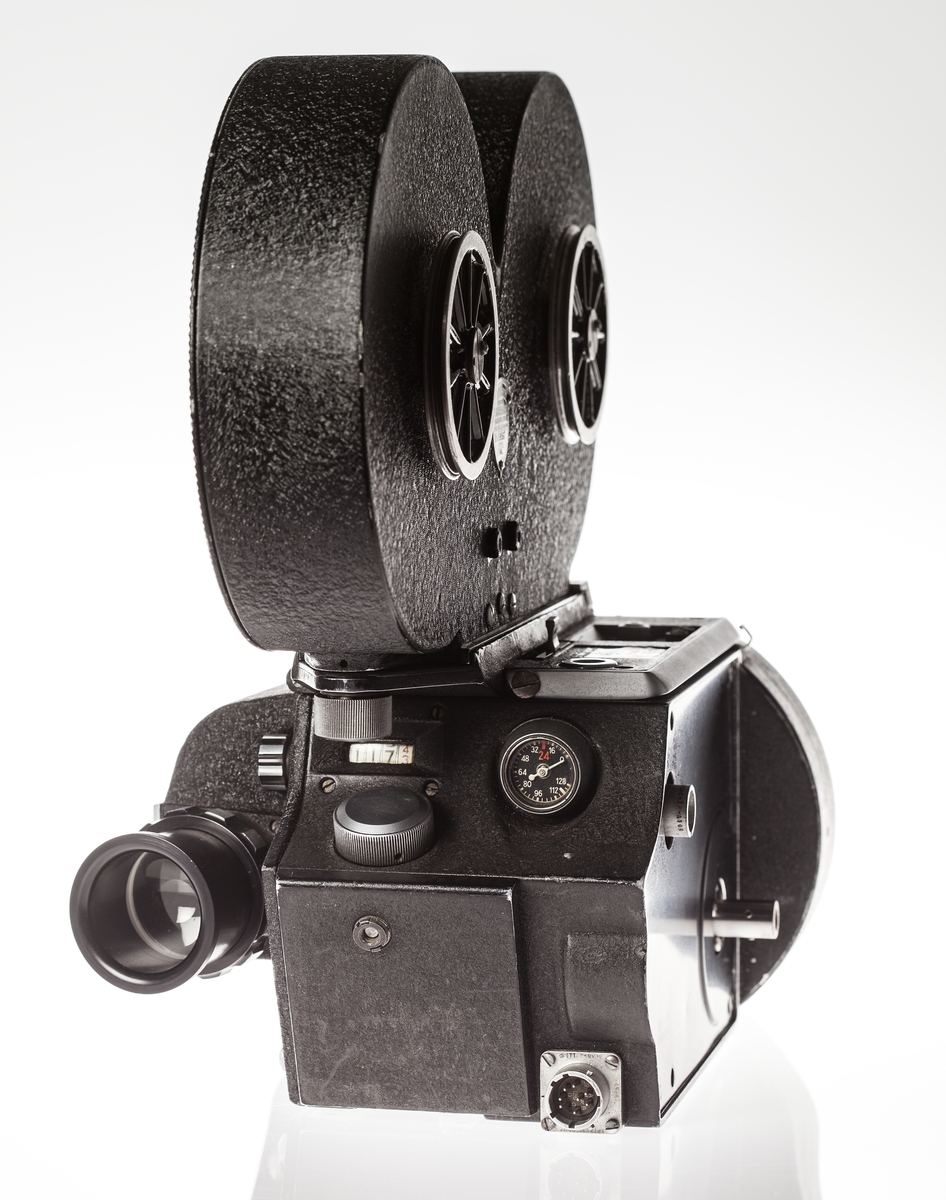 Filmkamera med magasin modell S4L nr 9567, 35 mm filmformat. Ett täcklock av metall som monteras istället för magasin medföljer.  Med Nikon 2x Telekonverter TC 201. Sladd för spänningsmatning. Passande höghastighetsmotor Mitchell modell 11D-2765 ser nr 100 i trälåda.