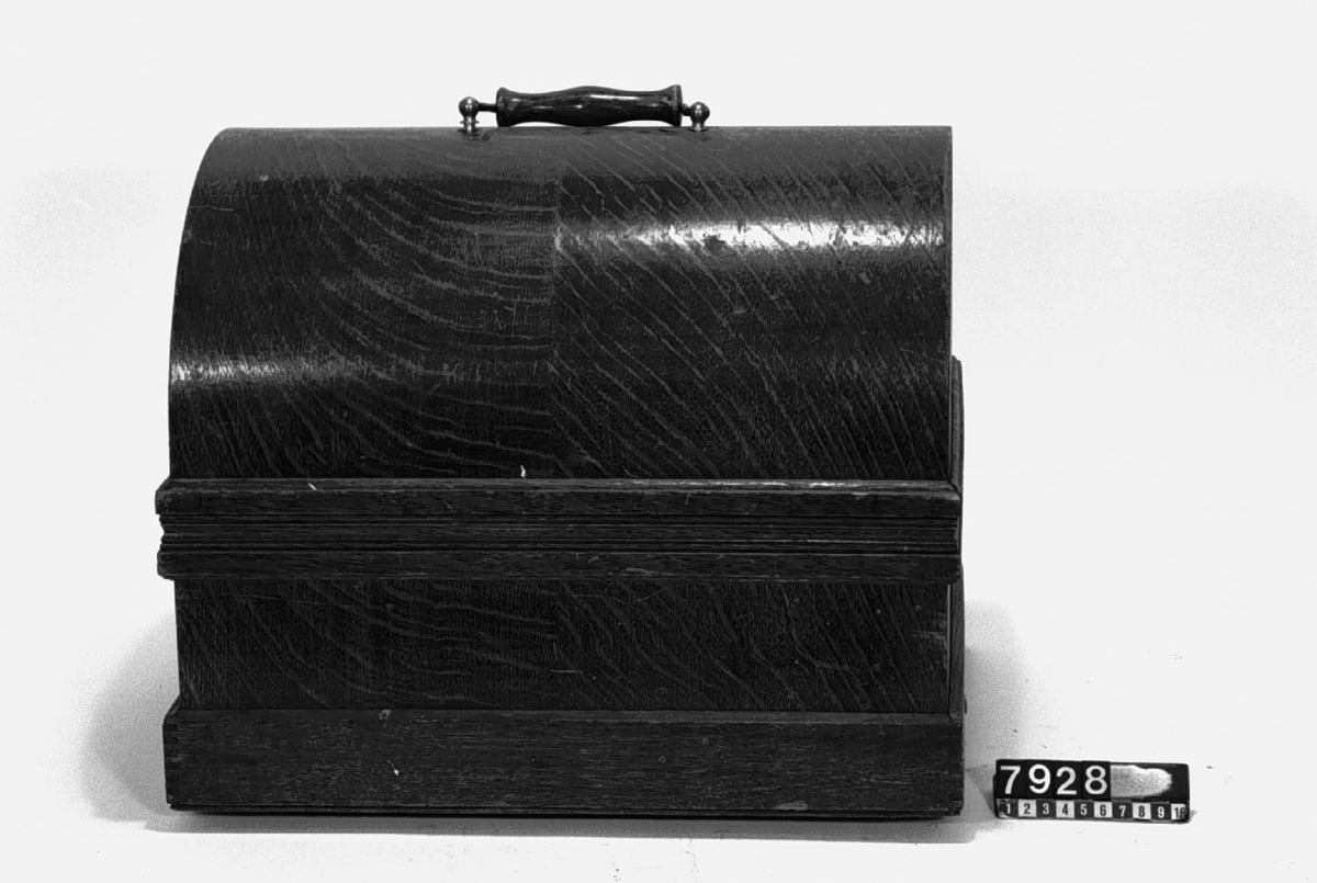Fonograf, modell C, för "Grand" rullar enligt Edison, större typ med 2 synkroniserande ljuddosor och stora ljudtrattar av mässing. Märkt: Thomas A Edison. Orange Co. NJ.
Tillbehör: 23 st. vaxrullar (vilka saknas) för återgivning av musik (12 st. hela, 11 st. skadade) packade i 2 korgväskor, 2 st. ljudtrattar i fodral, 2 st. ljuddosor (extra), 2 gummislangar (bytta) samt 1 vev. Flätad konisk korg med lock (trattarna skall skjutas in i varandra).