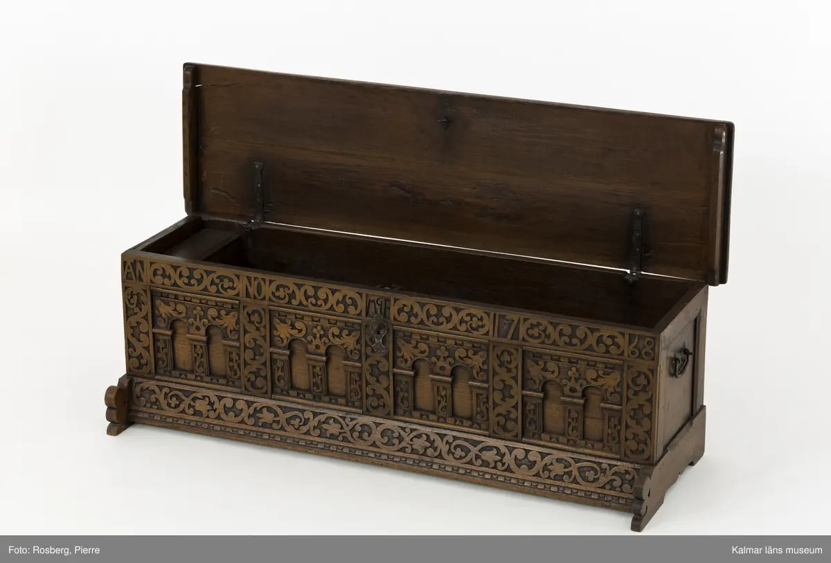KLM 45387. Ek, järn. Långsmal kista eller bänk i mörk ek med platt lock och rikt utskuren reliefdekor i renässansstil på kistans front. Texten "Anno 1768" och initialerna "MGF" är snidade på fronten. Bandgångjärn på lockets insida och på baksidans utsida. På båda kortsidorna finns smidda bärhandtag av järn. På kistans front finns en nyckelskylt och inne i kistan ett lås av smide. Inne i kistan finns en läddika på den vänstra sida. På frontstyckets ovansida är följande text inristad: "17 IF:MAGRET FREIN:71".