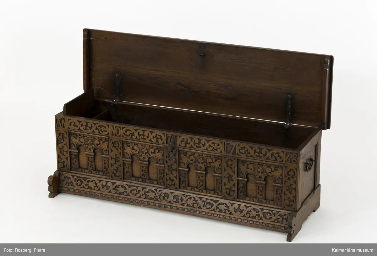 KLM 45387. Ek, järn. Långsmal kista eller bänk i mörk ek med platt lock och rikt utskuren reliefdekor i renässansstil på kistans front. Texten "Anno 1768" och initialerna "MGF" är snidade på fronten. Bandgångjärn på lockets insida och på baksidans utsida. På båda kortsidorna finns smidda bärhandtag av järn. På kistans front finns en nyckelskylt och inne i kistan ett lås av smide. Inne i kistan finns en läddika på den vänstra sida. På frontstyckets ovansida är följande text inristad: "17 IF:MAGRET FREIN:71".
