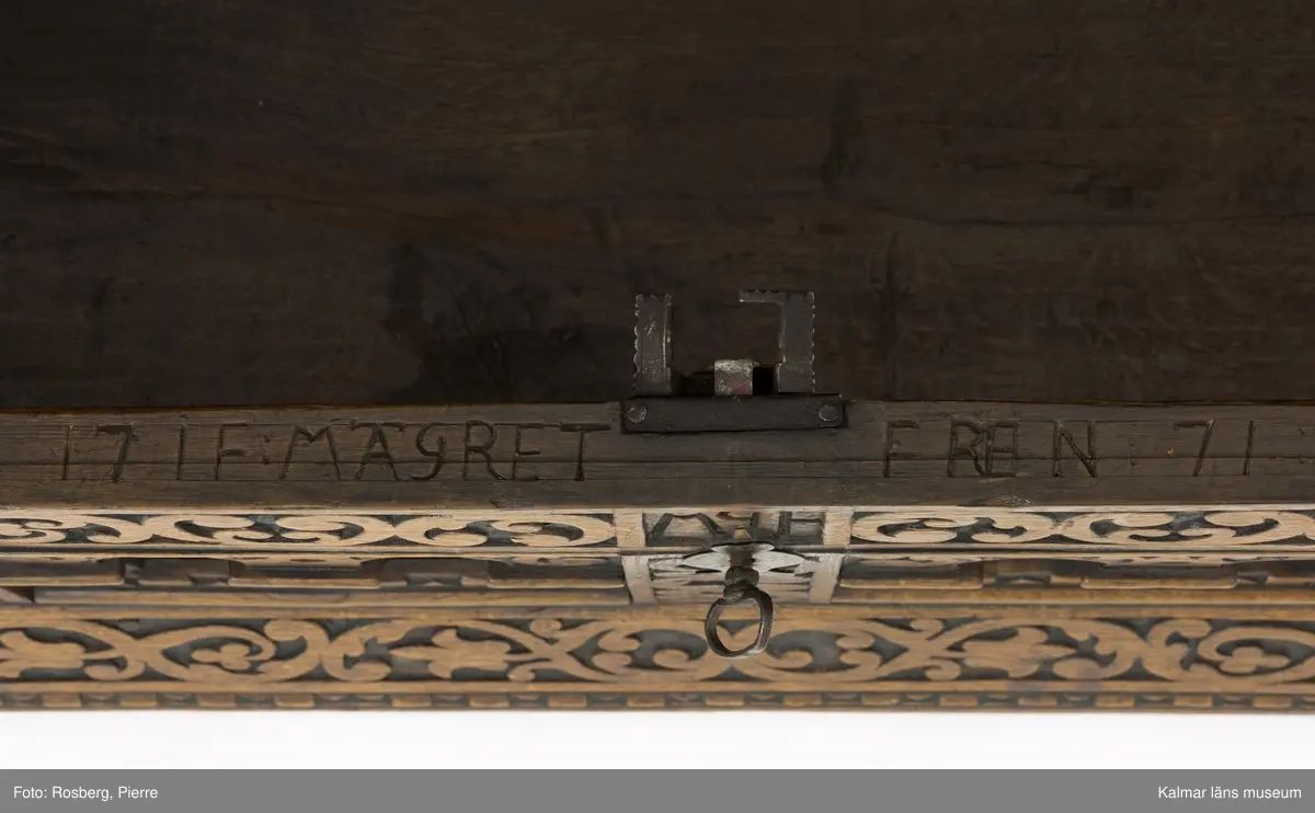 KLM 45387. Ek, järn. Långsmal kista eller bänk i mörk ek med platt lock och rikt utskuren reliefdekor i renässansstil på kistans front. Texten "Anno 1768" och initialerna "MGF" är snidade på fronten. Bandgångjärn på lockets insida och på baksidans utsida. På båda kortsidorna finns smidda bärhandtag av järn. På kistans front finns en nyckelskylt och inne i kistan ett lås av smide. Inne i kistan finns en läddika på den vänstra sida. På frontstyckets ovansida är följande text inristad: "17 IF:MAGRET FREIN:71".