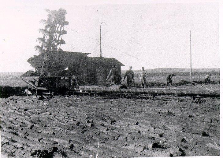 Rogestorps Bränntorvsfabrik 1917. "Tyska verket" helautomatisk torvupptagningsmaskin, användes 1917-1923. Hässleholms fabrik "kopierade" verket och byggde egna. Det så kallade Hässleholmsverket användes senare både på Rogestorps och Risholmens mossar. En "spion" (en konstruktör från Hässleholmsfabriken) arbetade en kortare tid vid Rogestorps Bränntorvfabrik och ritade av det "tyska verket" i smyg, berättar John Karlsson.