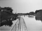 Kinda kanal.  Parti ovanför slussen vid Slattefors.
Med fotografiet erhöll fotografen 5:e plats i Svenska Turistföreningens pristävlan 1902.