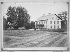 Bångbro Järnverk. Professor J.O. Carlbergs f.d. bostad från början av 1890-talet, inredd till arbetarbostad för Bångbro-arbetarna, ca 1880. Personerna på bilden från höger: Professor J.O. Carlberg och fru Carlberg (född Carlsvärd).