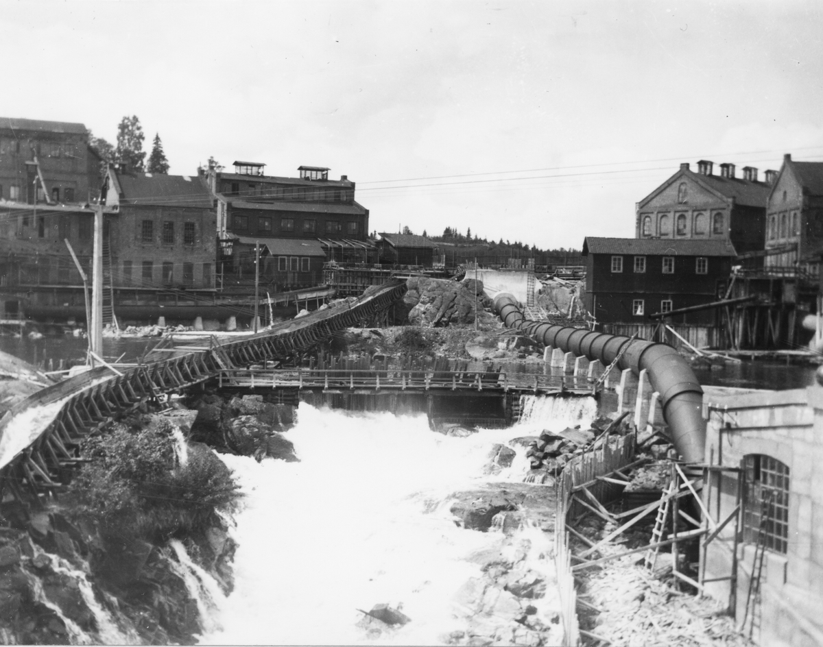 Industrimiljö med forsande vatten, vattenkraftverk.