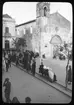 Skioptikonbild från institutionen för fotografi vid Kungliga Tekniska Högskolan. Bilden är troligen tagen av John Hertzberg under en resa i Europa. Hertzberg blev docent i fotografi 1921vid Kungliga Tekniska Högskolan i Stockholm. Gatuliv vid kyrkan.