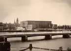 Vy över Kungliga Slottet Stockholm. Sett från Skeppsholmen. Med Skeppsholmsbron framför.