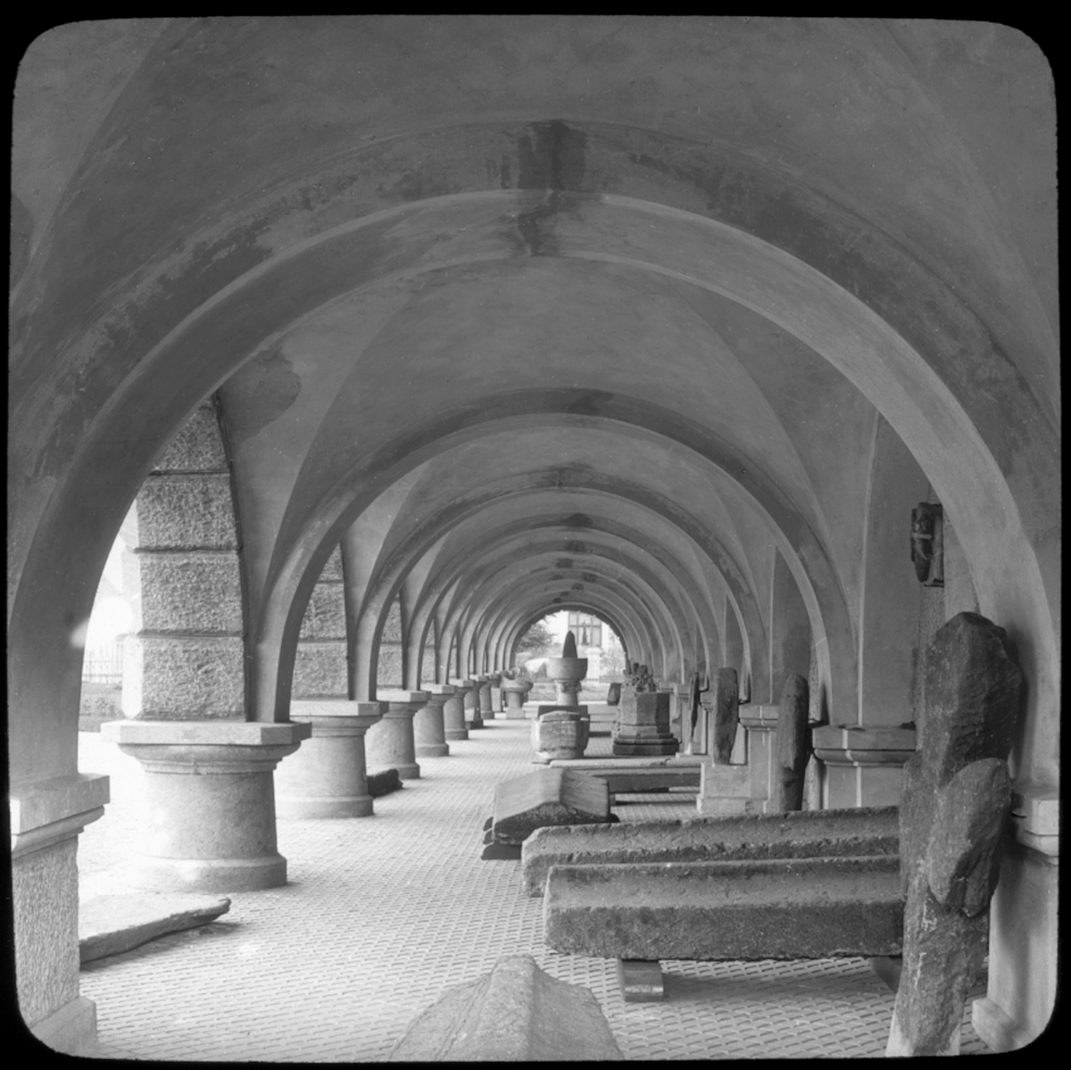 Skioptikonbild från institutionen för fotografi vid Kungliga Tekniska Högskolan. Motiv föreställande en valvgång i Bergen Museum, Museumshagen. Bilden är troligen tagen av John Hertzberg under en resa i Europa.