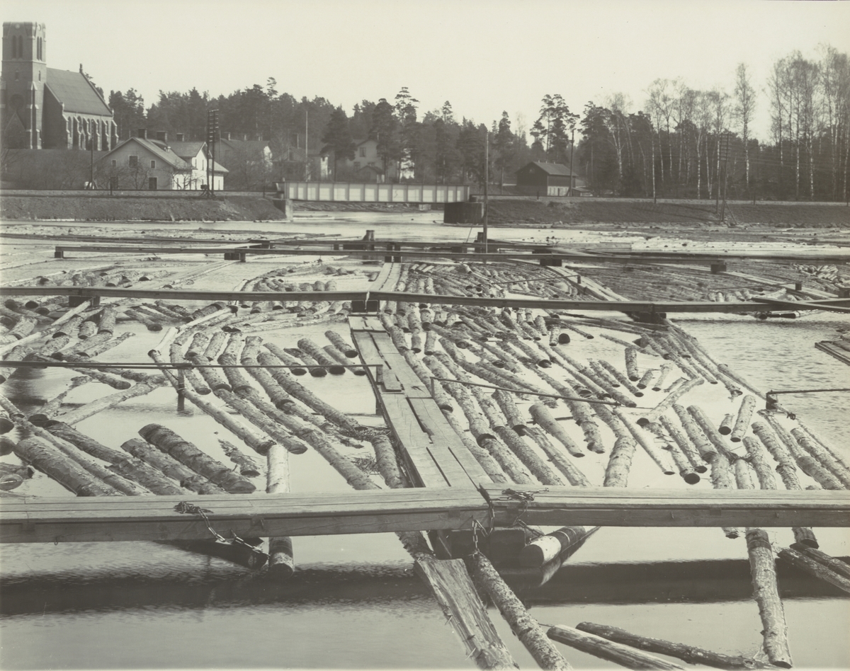 Boxholms Järnverk. Sågdammen omkring 1918. I förgrunden timmersorteringen. Vidare bakåt i bild stambanebron, Strömsholmen och kyrkan.