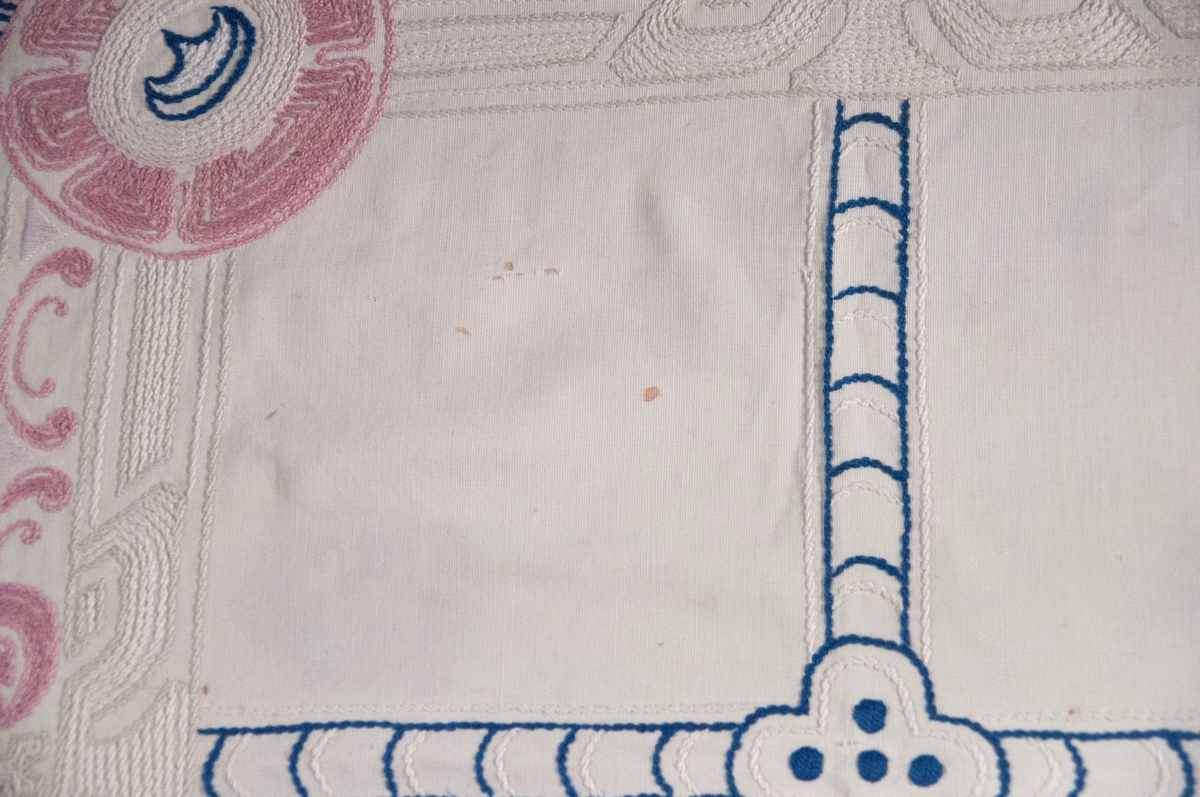 Bomullslerret, falda og brodert med attersting.