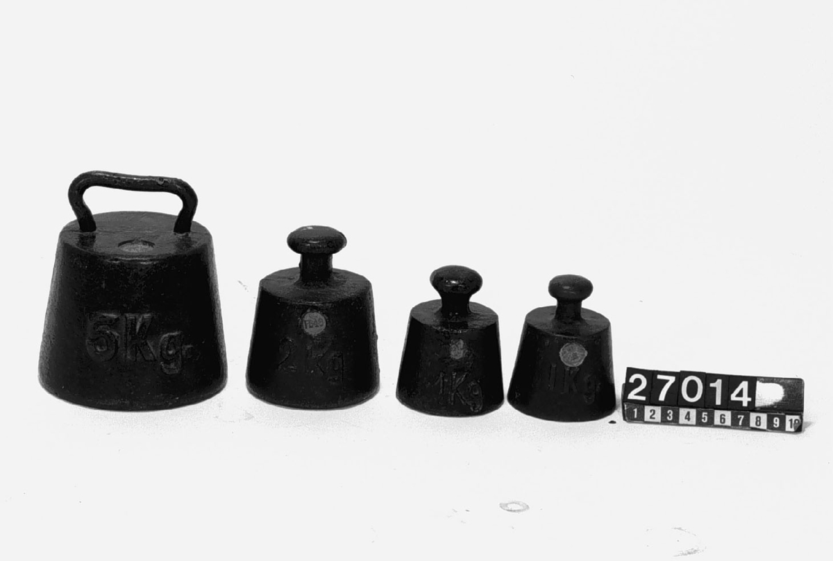19 st. vikter, 5 kg-5 hg av gjutjärn, 5 hg-10 g av mässing jämte ställpatta av trä, krönta åren 1899-1941. Vikter 5.2 och 1 g saknas. 
Vikter svarta 
1 st. 5 kg, 
två st. 2 kg, två st. 1 kg, 5 hg. Vikter av mässing i viktbräde: 5 hg, två st. 2 hg, 
två st. 1 hg, två st. 50 gr, fyra st. 20 gr, 10 gr. Flertalet av vikterna är märkta MJV = Mynt- och Justeringsverket.