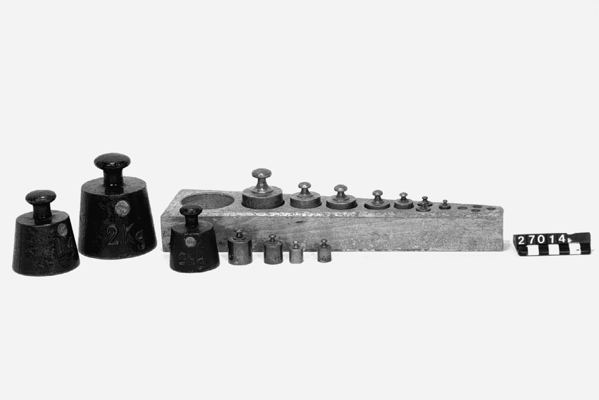 19 st. vikter, 5 kg-5 hg av gjutjärn, 5 hg-10 g av mässing jämte ställpatta av trä, krönta åren 1899-1941. Vikter 5.2 och 1 g saknas. 
Vikter svarta 
1 st. 5 kg, 
två st. 2 kg, två st. 1 kg, 5 hg. Vikter av mässing i viktbräde: 5 hg, två st. 2 hg, 
två st. 1 hg, två st. 50 gr, fyra st. 20 gr, 10 gr. Flertalet av vikterna är märkta MJV = Mynt- och Justeringsverket.