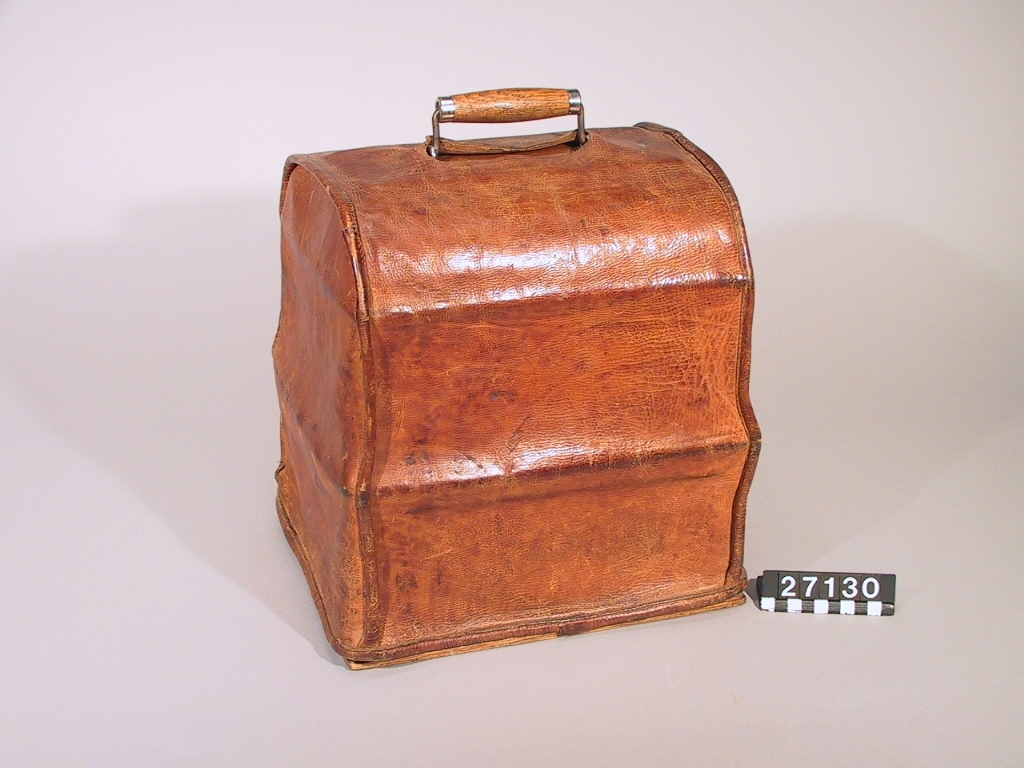 Fonograf, med svarvanordning. Avsedd för 5 tums vaxrullar, 120 varv/minut. Skylt: "The Graphophone patented May 4 1886 .... Mar 30 1897 Manufactured by the American Graphophone Company, New York, N.Y. Type HG 1216".
Tillbehör: Lösa delar: apparat, vev, ljuddosa för återgivning, ljuddosa för upptagning (båda i pappask), böjd tratt, huv av trä samt ytterhuv av brunt läder.