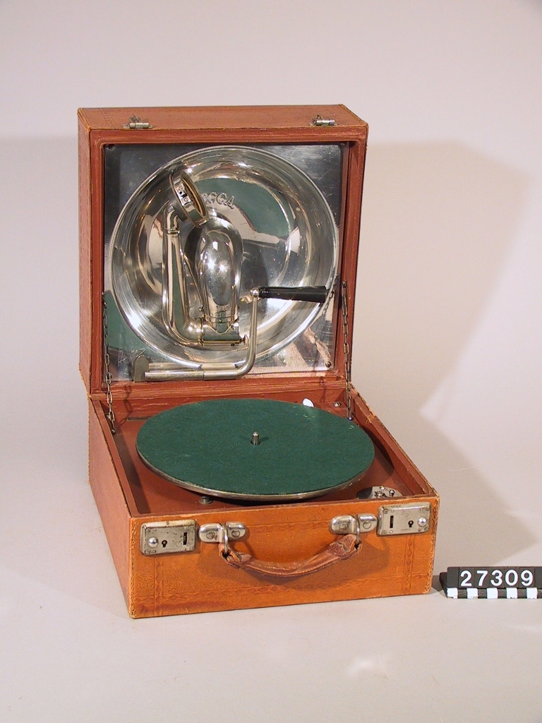 Resegrammofon, "Decca", med skålformad ljudtratt och ljudarm av aluminium på insidan av locket enligt engelskt patent år 1914. Med verk och dosa från Schweiz. Skylt i lådan: "Keith Prowse & Co Ltd. Branches all over London". Ljuddosan: "Dulcephone trade mark swiss made. For all gramophones. The New "Crescendo soundbox". Stämplat på ljudarmen: "Regd 631877 Patent 3033".