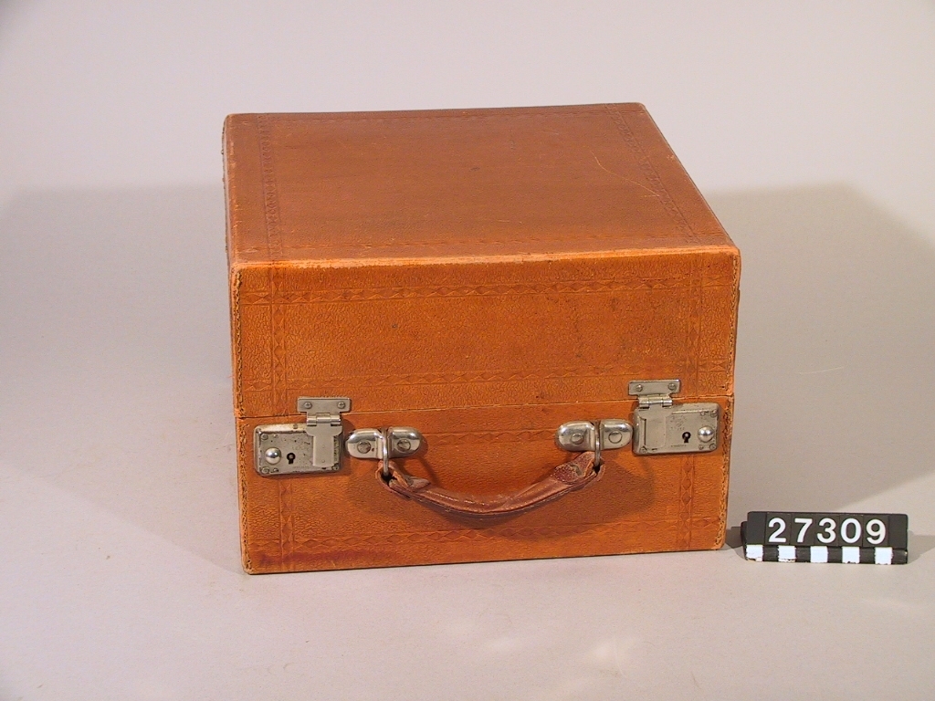 Resegrammofon, "Decca", med skålformad ljudtratt och ljudarm av aluminium på insidan av locket enligt engelskt patent år 1914. Med verk och dosa från Schweiz. Skylt i lådan: "Keith Prowse & Co Ltd. Branches all over London". Ljuddosan: "Dulcephone trade mark swiss made. For all gramophones. The New "Crescendo soundbox". Stämplat på ljudarmen: "Regd 631877 Patent 3033".