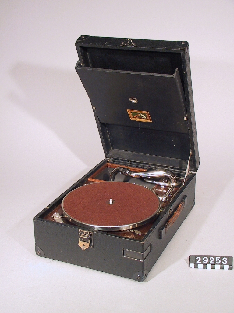 Resegrammofon, klädd md svart konstläder. Ljuddosa av fabriksmärket HMV 4.