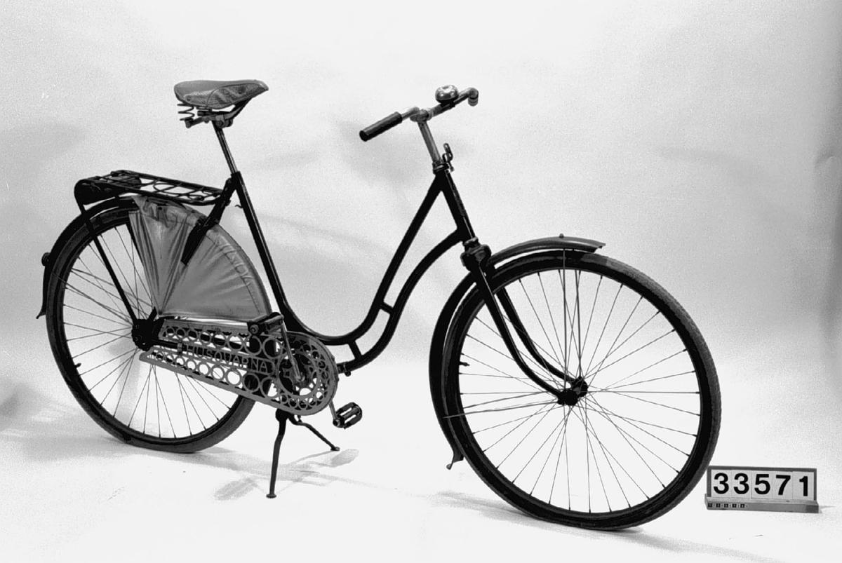 Damvelociped av stål, med gummidäck, 28 tums hjul, brun sadel, parkeringsställ och kjolskydd av galon.