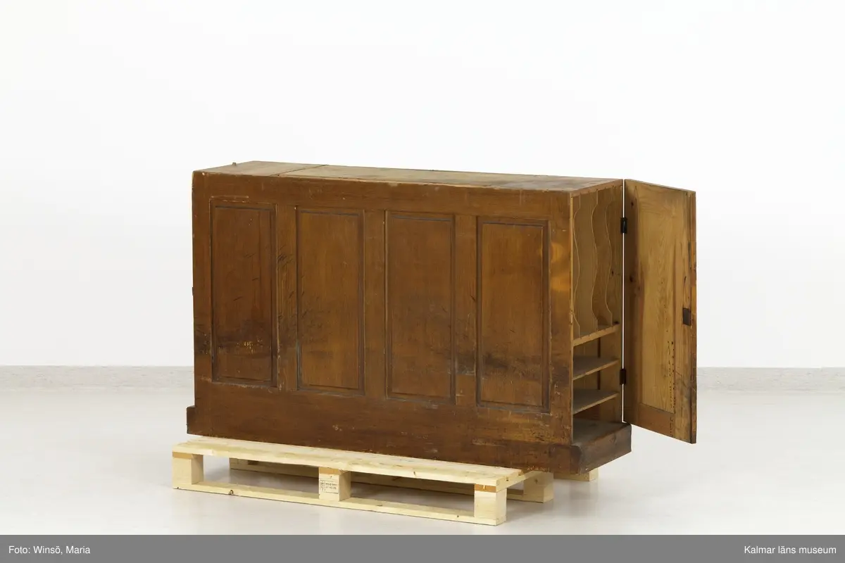 KLM 45471:1-2. Hurts, skrivbordshurts. Två stycken. Avlång hurts utan överdel. Av trä, ådringsmålad i ljusbrun kulör. Hurts :1 har på vardera kortsida en dörr med inbyggt lås. Inuti utrymmena diverse fack och hyllor. På ena långsidan en dubbeldörr med inbyggt lås. Utrymmet är indelat i två fack och åtta hyllplan. På några av hyllplanens främre kant är skrivet: Normal-skrivpapper, Skrivpapper 375x480, Postpapper 47 ark, Läskpapper 8 ark. Hurts :2 har på vardera kortsida utdragbara lådor, ett flertal saknas. Båda hurtsarna är försedda med spegeldörrar/väggar.