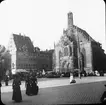 Skioptikonbild med motiv av marknad framför Liebfrauenkirche, Nürnberg.
Bilden har förvarats i kartong märkt: Nürnberg IX. 1901. Text på bild: 