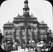 Skioptikonbild med motiv av marknad på torg framför rådhuset i Lüneburg.
Bilden har förvarats i kartong märkt: Resan 1906. Lüneburg.  Altona. Text på bild: 