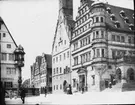 Skioptikonbild med motiv av rådhuset i Rothenburg. Torget med fontänen Herterich Brunnen bredvid.
Bilden har förvarats i kartong märkt: Vårresan 1910. Rothenburg XXIX.. Text på bild: 