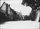 Skioptikonbild med motiv av lekande barn på gata vid muren söder om Kaiserburg, slottet i Nurnberg.
Bilden har förvarats i kartong märkt: Vårresan 1910. Nürnberg XIX.. Text på bild: 