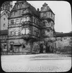 Skioptikonbild med motiv av Alte Hofhaltung, gamla domstolen i Bamberg, främre fasad på Cathedral Square.
Bilden har förvarats i kartong märkt: Resan 1906. Bamberg 8.