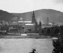 Skioptikonbild med motiv av valvbron Alte Brücke över floden Neckar, Heidelberg. I bakgrunden syns katedralen i Heidelberg.
Bilden har förvarats i kartong märkt: Resan 1906. Heidelberg. 8.