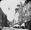 Skioptikonbild med motiv av gatan Burgstrasse i Nürnberg. Vid sidan skymtar St. Sebalduskirche.
Bilden har förvarats i kartong märkt: Vårresan 1910. Nürnberg 9. XVI.. Text på bild: 