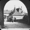 Skioptikonbild med motiv av en man och två kvinnor gående på gata i Rothenburg.
Bilden har förvarats i kartong märkt: Vårresan 1910. Rothenburg. XXX. Text på bild: 