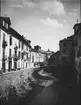 Skioptikonbild med motiv av gata vid flod i Granada.
Bilden har förvarats i kartong märkt: Höstresan 1910. Granada 9. N:24