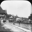 Skioptikonbild med motiv från Schwäbisch Hall. Pojkar på mur vid floden Kocher, Mauer Strasse Brücke.

Bilden har förvarats i kartong märkt: Resan 1911 Schwäbische Hall. Schloss Kronburg. XX.. Text på bild: 