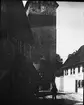 Skioptikonbild med motiv av man vid stadmurstorn i Münnerstadt.
Bilden har förvarats i kartong märkt: Vårresan 1910. Münnerstadt 9. VII.