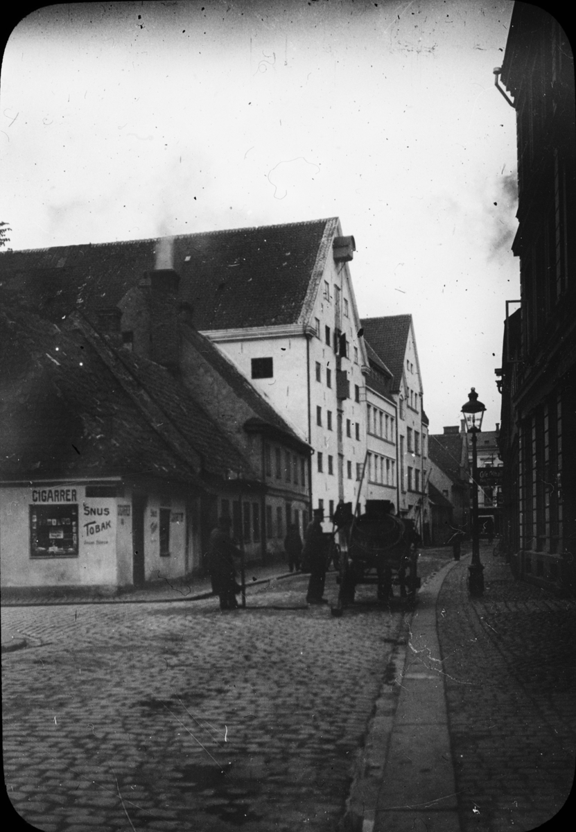 Skioptikonbild. Fotografiet är taget en bit in på Per Weijersgatan. Gatan in till vänster är Hjulhamnsgatan. Bakom ryggen på fotografen ligger Engelbrektsgatan. 
Bilden har förvarats i kartong märkt: Resan 1912. Malmö. Ystad. Rostock. Text på bild: "Per Vayersgatan 1912".