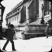 Skioptikonbild med motiv av man utanför Johannis Kirche, Rothenburg.
Bilden har förvarats i kartong märkt: Vårresan 1910. Rothenburg. XXII. Text på bild: 