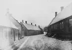 Skioptikonbild med motiv frän gränd i Båstad.
Bilden har förvarats i kartong märkt: Höstresan 1907. Båstad 7. N: 1