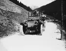 Skioptikonbild med motiv av Sigurd Curmans sällskap i bil på landsväg i Tyskland eller Sydtyrolen, Italien.
Bilden har förvarats i kartong märkt: Höstresan 1904. Pordoi 8. Bozen 6. N:17.