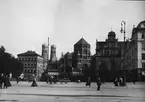 Skioptikonbild med motiv från München, Westenriederstrasse med synagogan och Künstlerhaus, Marienkirche i bakgrunden.

Bilden har förvarats i kartong märkt: Höstresan 1909. München 8. No:26. Text på bild: 