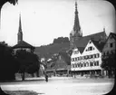 Skioptikonbild med motiv fråg Reutlingen. Gästhus/ hotell med kyrkan Evangelische Kirche Reutlingen i bakgrunden.
Bilden har förvarats i kartong märkt: Resan 1906. Reutlingen 2. Vägen till Tübingen 4.