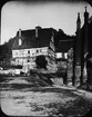 Skioptikonbild med motiv av hus intill Stiftskirche i Herrenberg.
Bilden har förvarats i kartong märkt: Resan 1908. Herrenberg.