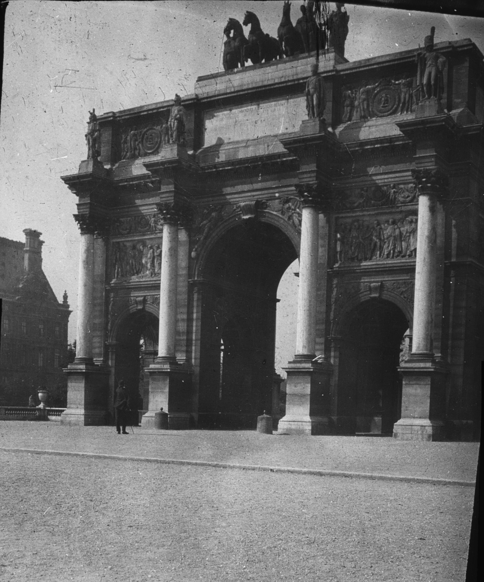 Skioptikonbild med motiv av triumfbåge vid Louvren, Arc de triomphe du Carrousel, Paris.
Bilden har förvarats i kartong märkt: Höstresan 1907. Bordeaux 2. Paris 5. No: 21. Text på bild: "Ave de Triompl. Place du Carrousel".