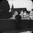 Skioptikonbild med motiv av man på bro i Tübingen med kyrkan i bakgrunden.
Bilden har förvarats i kartong märkt: Resan 1908. Tübingen 7. V.