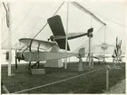 Svenska Aeronautiska Sällskapets utställning i maj 1915 vid Stallmästaregården i Stockholm. Thulinfabrikens monoplan av Morane-Saulnier-typ, byggd på fransk licens. I förgrunden ett Thulin-plan typ D (Morane- Saulnier Parasol), med först 80, sedan 90 hkr luftfylld rotationsmotor. Planet hade överliggande vinge. Topphastighet ca 115 km/tim. Bakom, upphöjt, syns två Thulinmonoplan typ B (Morane-Saulnier) med först 60, senare 90 hkr motor Le Rhône.