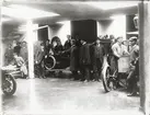 Elever vid Eric Lundviks körskola, samlade kring automobiler i garagelokal, omkring 1915-1920.