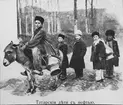 Skioptikonbild från A.W. Cronquists besök i Baku- oljedistrikt 1903.
Barn fraktar fotogen med åsna.