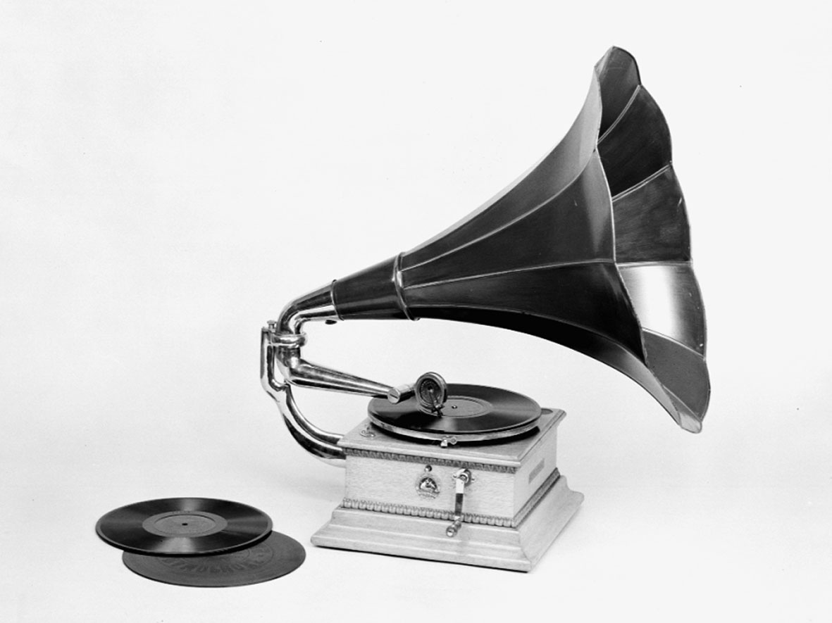 Grammofon, med enkelfjäderverk och jättetratt av lackerad plåt. Höjd: 700 mm med tratt. Lösa delar: Tratt och vev.
Består av
TM14615:1 Grammofon
TM14615.2