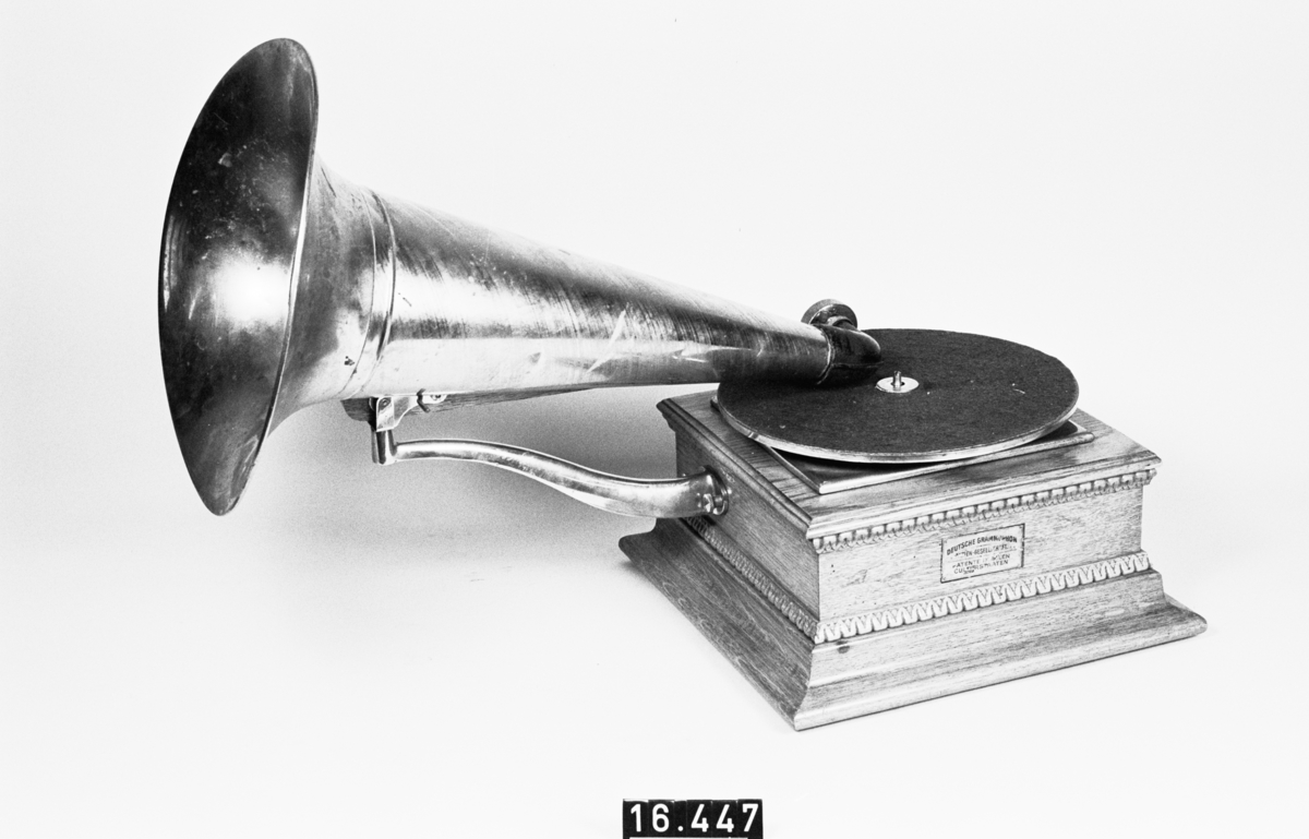 Grammofon. Ljuddosa i original cylindrisk kartong, med etikett på kartongen: "Grammophon-Concert-Schalldose". Ljuddosan dock av fabrikatet G&T Ltd, Made in USA. Etikett på apparaten: "Deutsche Grammophon Aktien-Gesellschaft Patente in allen Culturstaaten". Annan etikett har funnits ovanpå.
Tillbehör: Lösa delar: verk i låda, vev, tratt, arm till tratt, "Gramophone & Typewriter Ltd, London-Berlin-Paris".