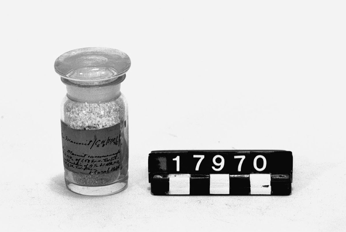 Prov på nitromannit, troligen sprängämne, i glasburk med etikett: "Nitro-Mannit (C6H8/NO3/6) Framst.-Mannit sammanrifs med HONO2 af 1.52 sp.v. till lösning: en blandning af 4 Â« d l HONO2 & 10 Â« H2 O4 SO4 tillsättes de Laval 1876".