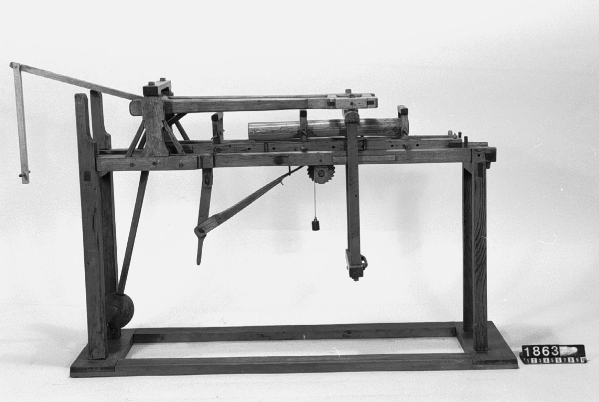 Modell av handdriven brädsåg. Text på föremålet: "Brädsåg för hand med ställning. B-d-11 N:o 175".
