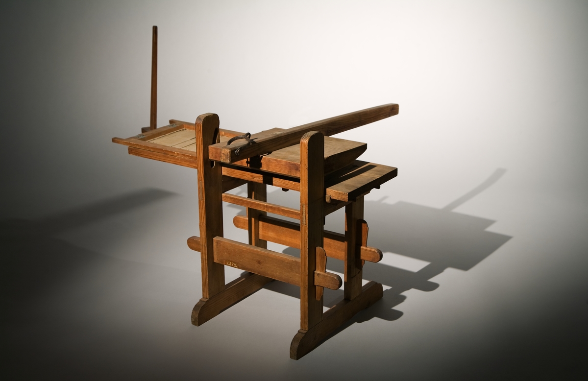 Modell av press för linjering av papper. Text på föremålet: "N:o 180. F-a-g-2 XIII. 25" (texten delvis försvunnen).